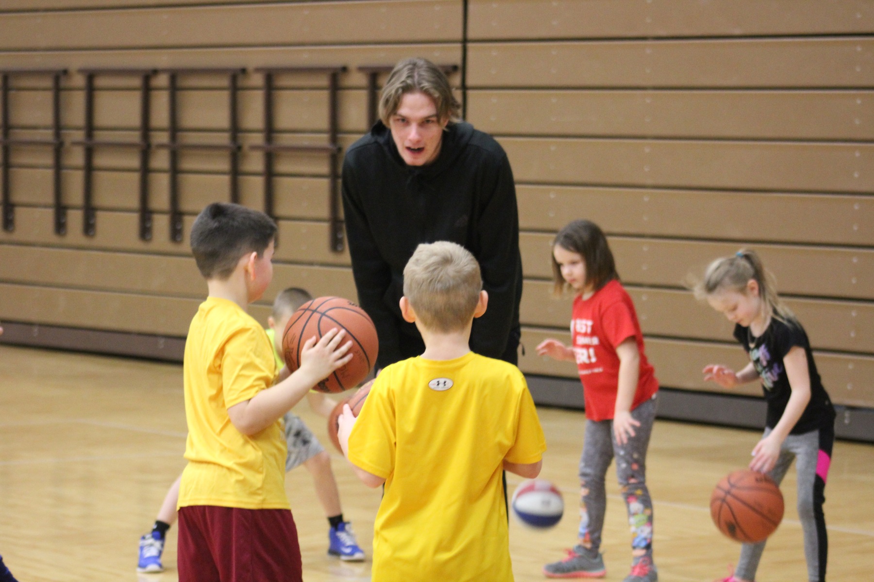 NIACC men's basketball player Raymond Harding helps at the Mason City Parks and Recreation clinic Wednesday morning in the NIACC gym.