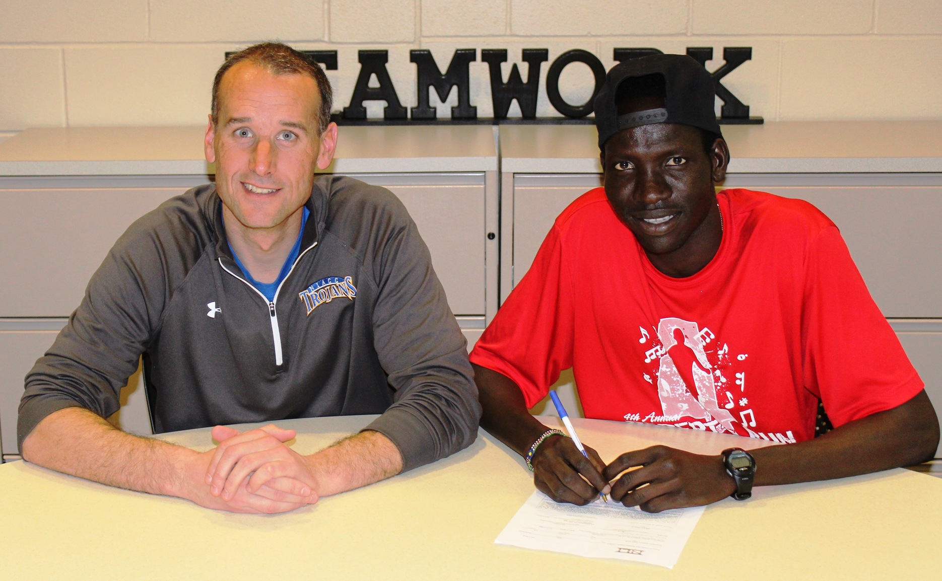 NIACC's Wal Khat, with his coach Curtis Vais, signed a national letter of intent Thursday to run at the University of Northern Iowa.