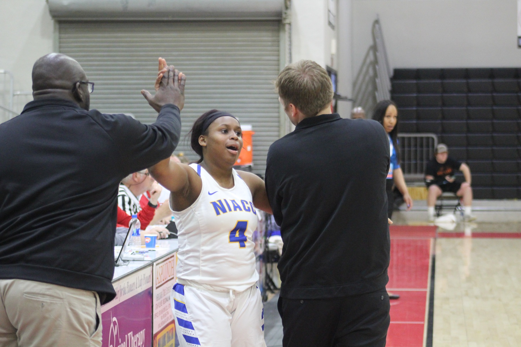 TT Longs gets high fives from NIACC coaches Todd Ciochetto and Jareese Willams Sr.
