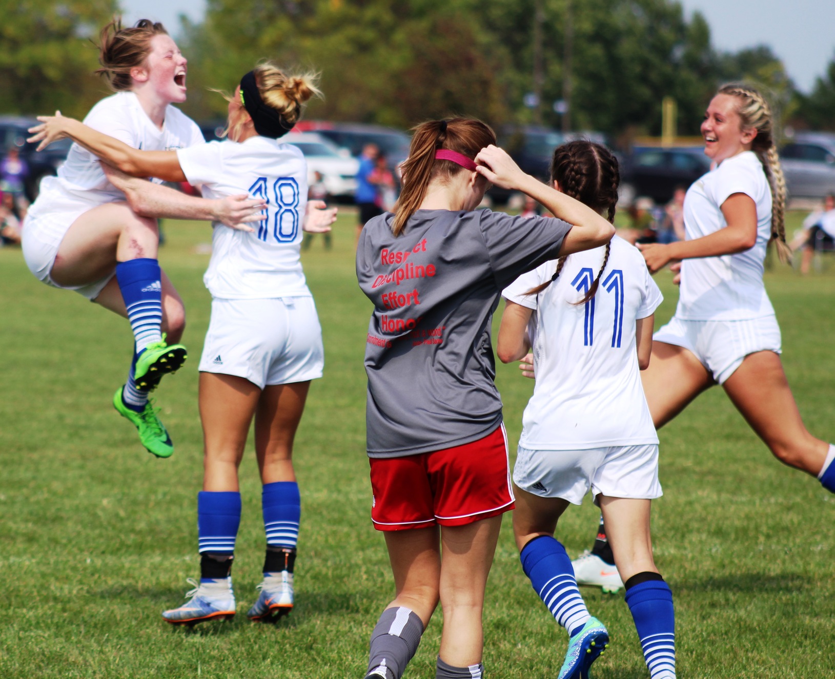 Emma Eden (in air) celebrates after scoring a goal off a header on a corner kick in first half of Sunday's match.