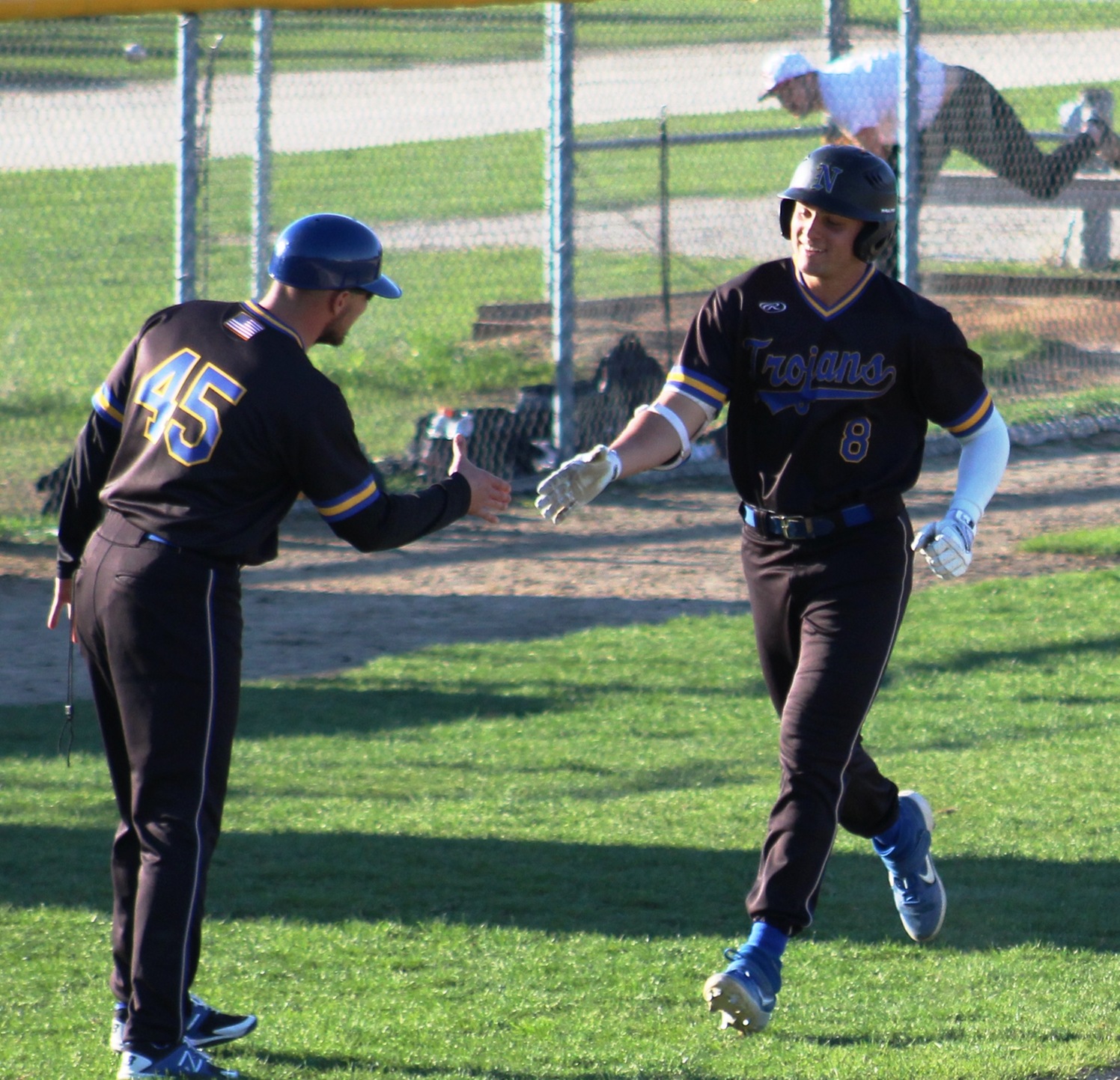 NIACC's Ben Fitzgerald rounds third base and gets hand shake from third-base coach Shawn Schlecther in a game at Ellsworth on Friday.