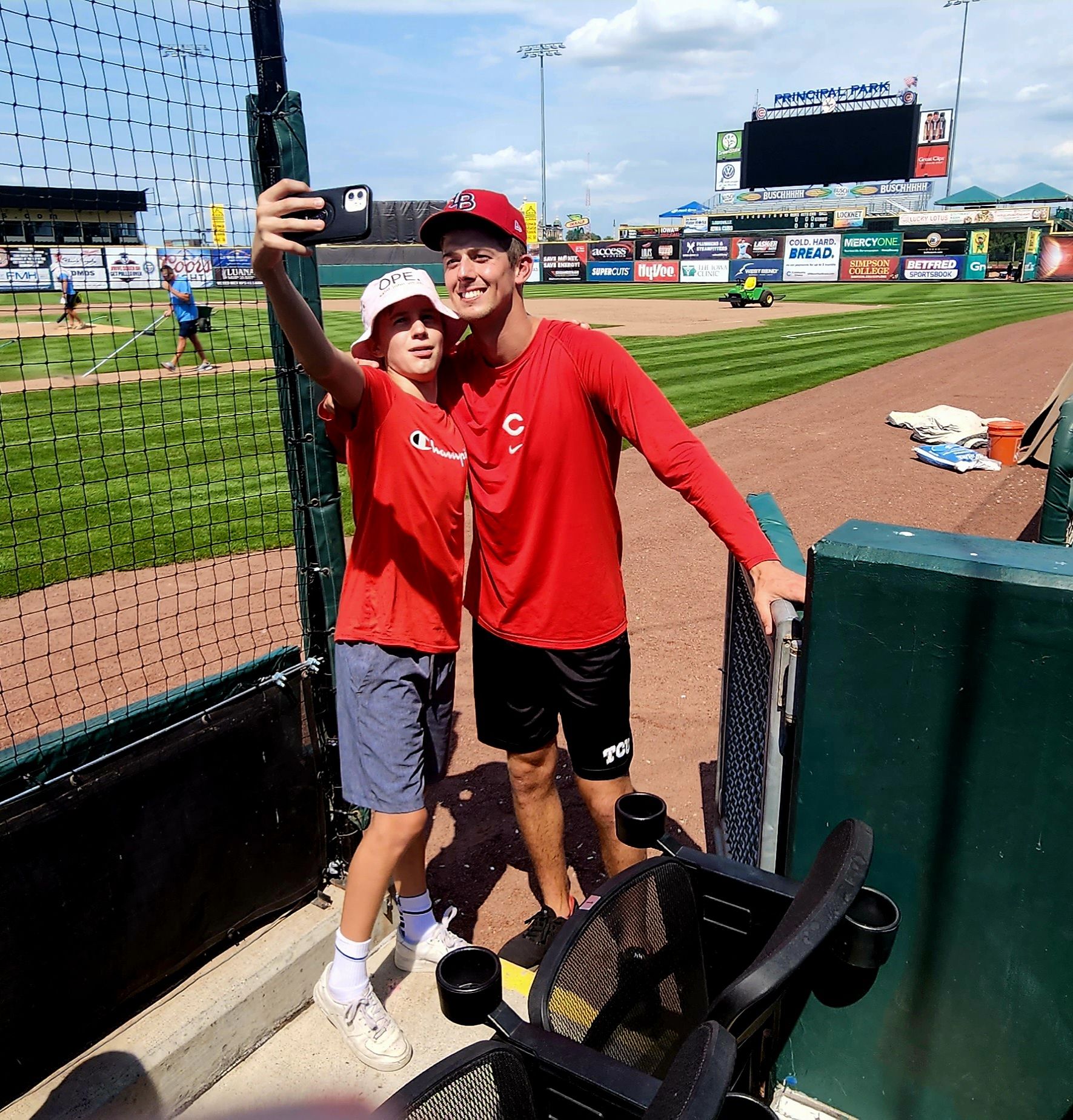 Brandon Williamson of the Louisville Bats takes a selfie with a fan after Thursday's game in Des Moines.