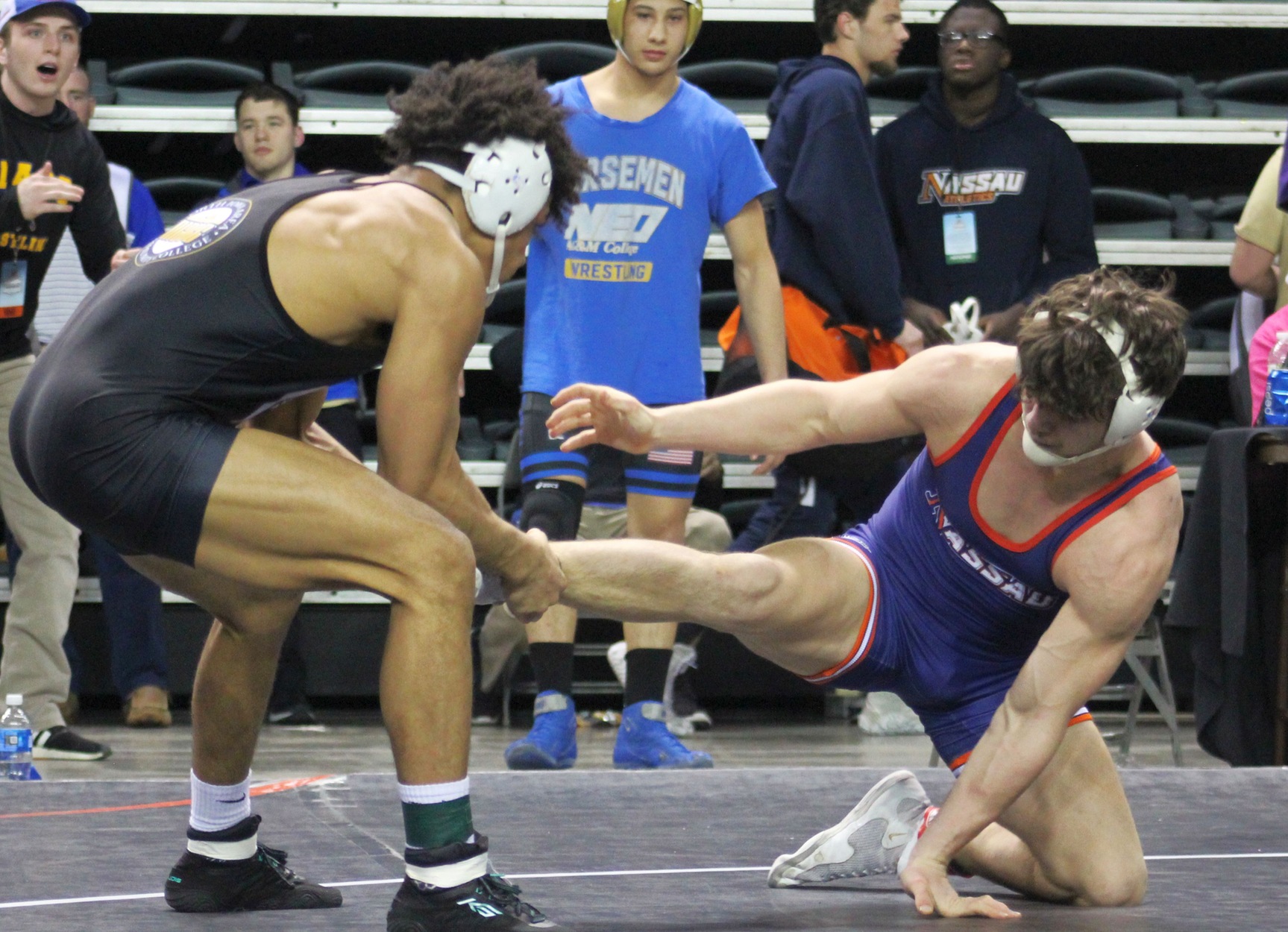 NIACC's Christian Minto pulls the leg of Nassau's Paul Illicete in Friday's 165-pound quarterfinal match Friday.